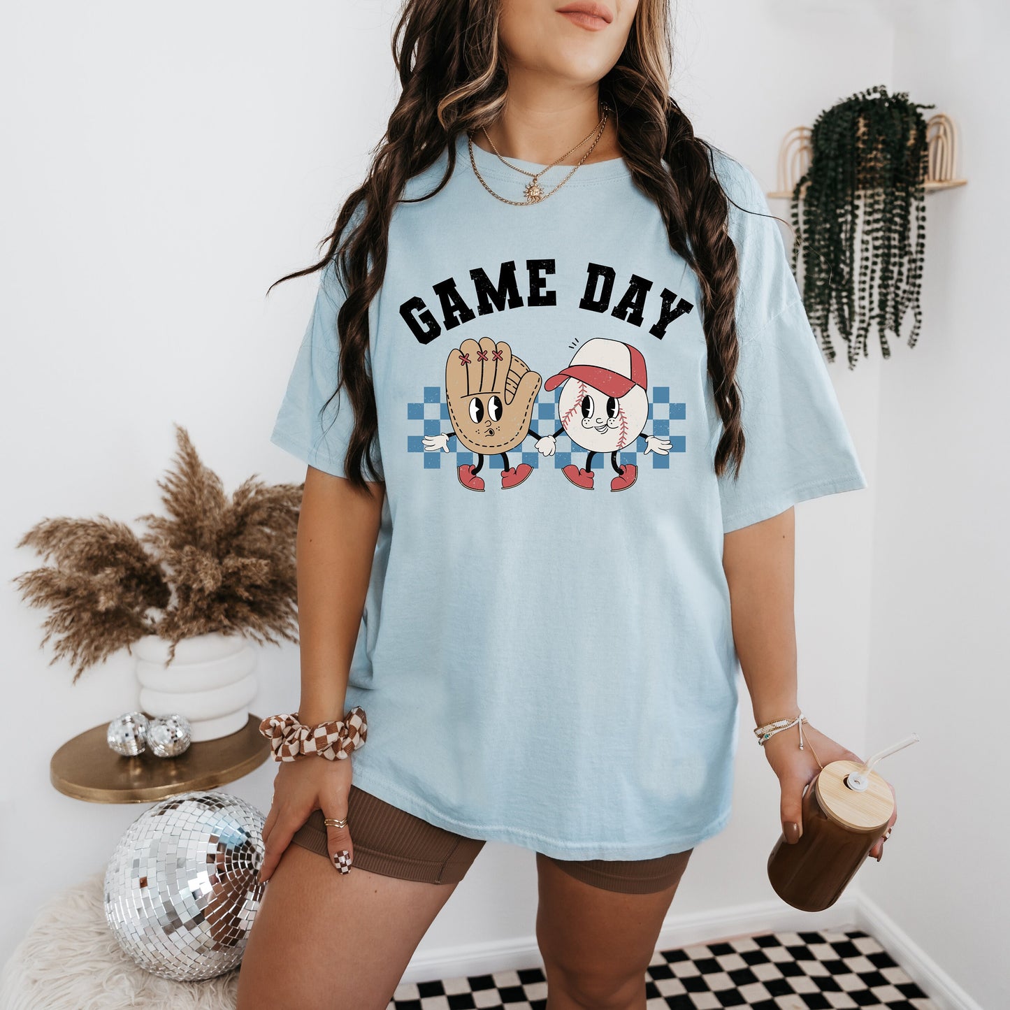 a woman standing in a room with a game day shirt on