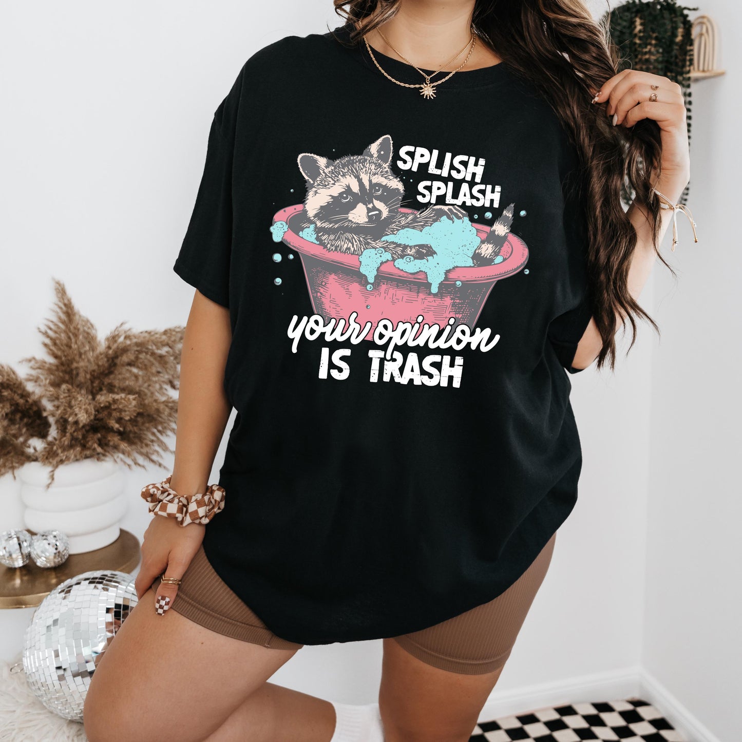 a woman wearing a black t - shirt with a raccoon in a bath