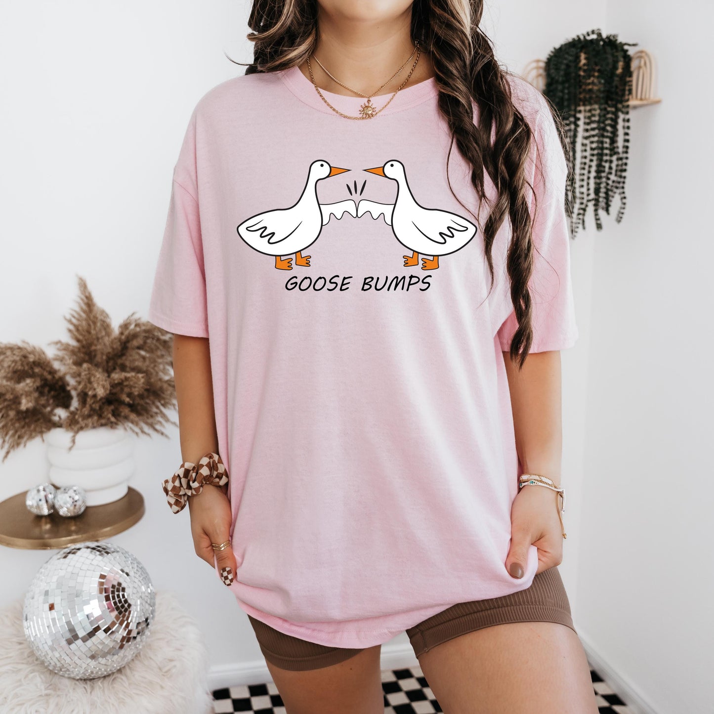 a woman wearing a pink goose bumps t - shirt