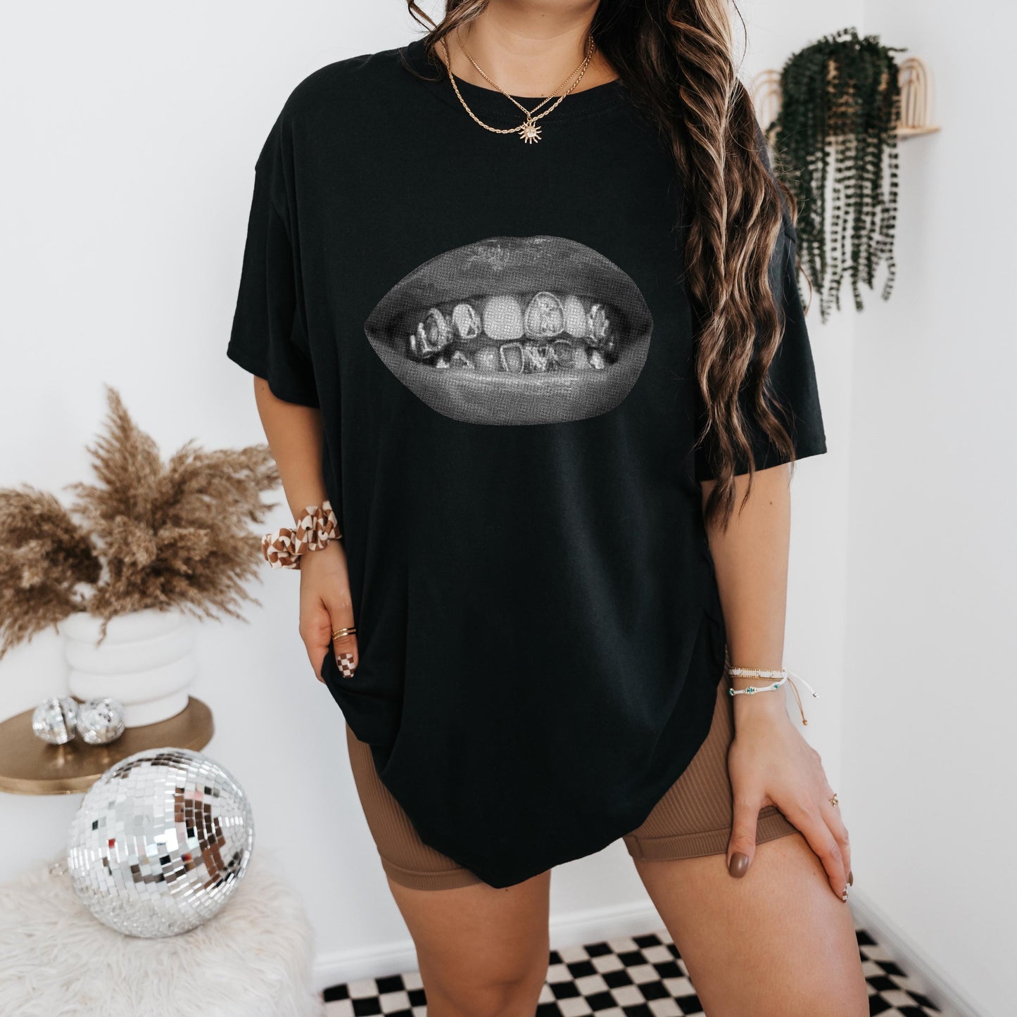 a woman standing in front of a mirror wearing a black t - shirt with a