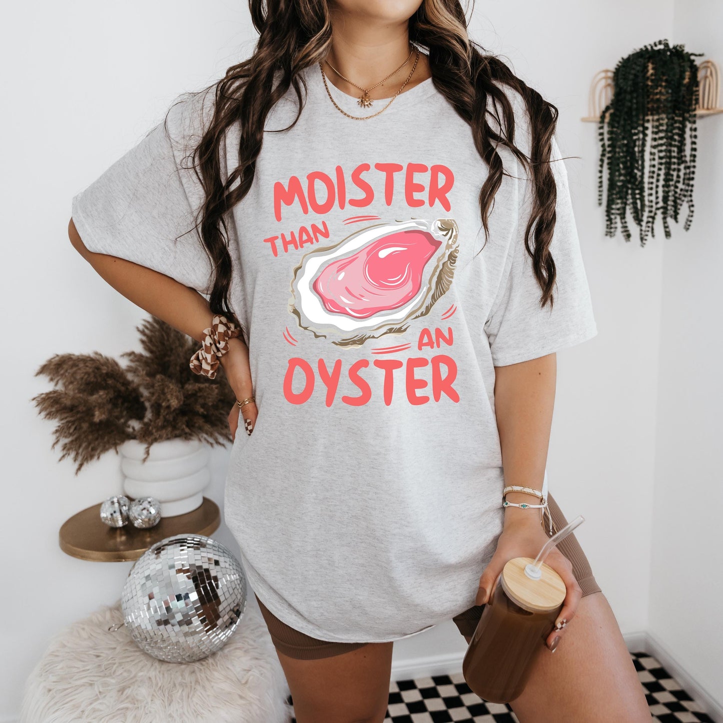 a woman standing in front of a wall holding a cup of coffee