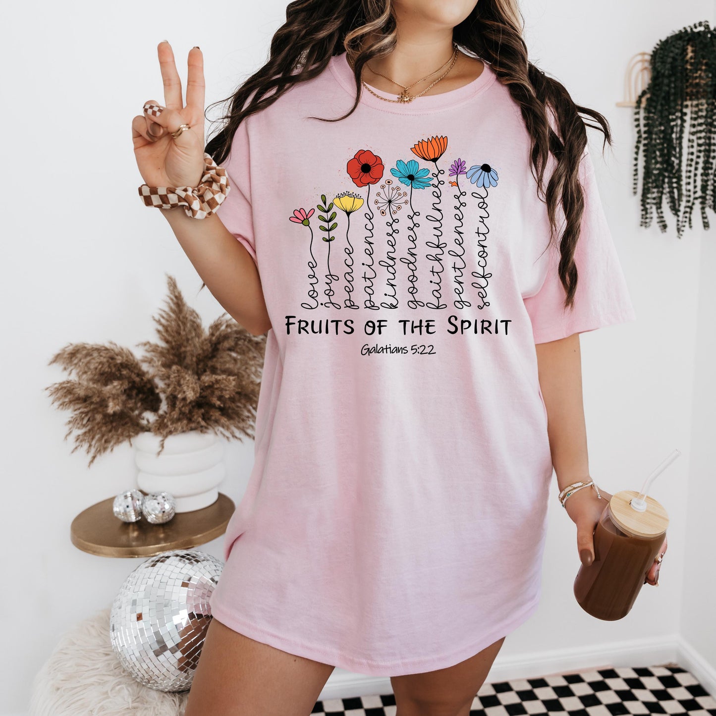a woman in a pink shirt holding a cup of coffee
