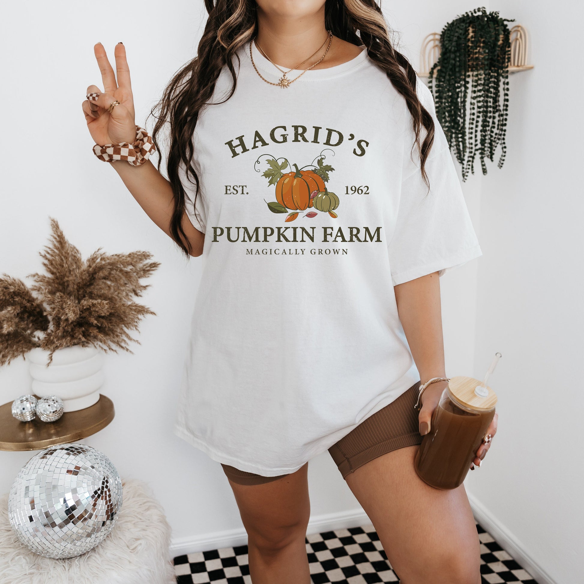 a woman standing in front of a wall holding a cup of coffee