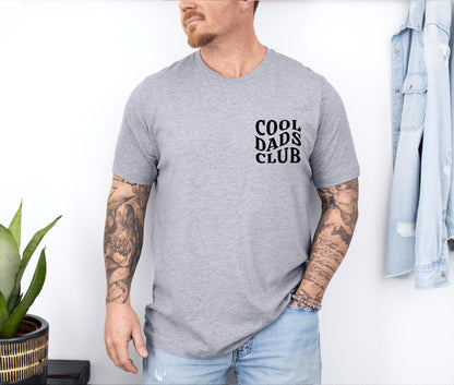 a man with a tattooed arm standing next to a plant