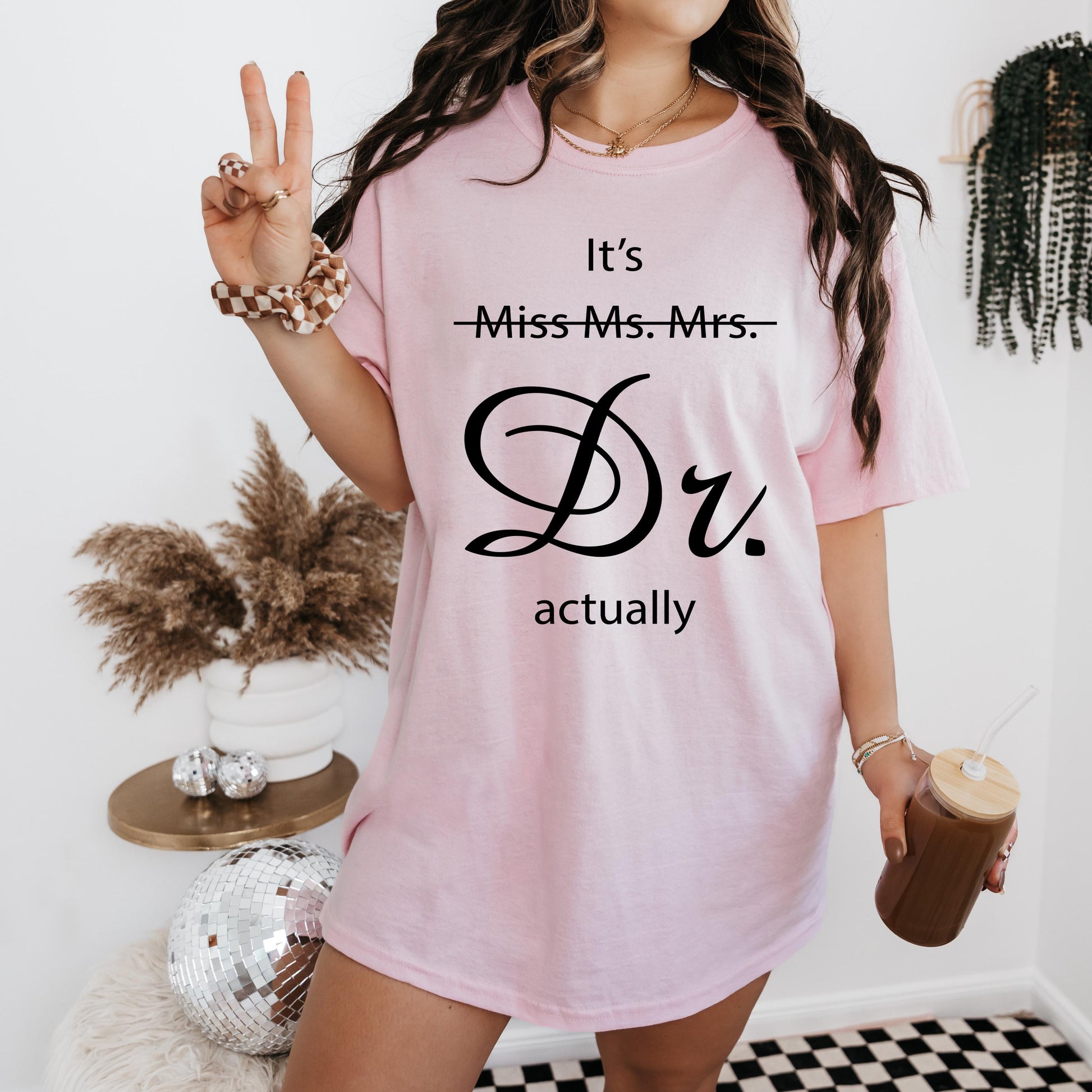 a woman wearing a pink t - shirt with the words it's miss mrs