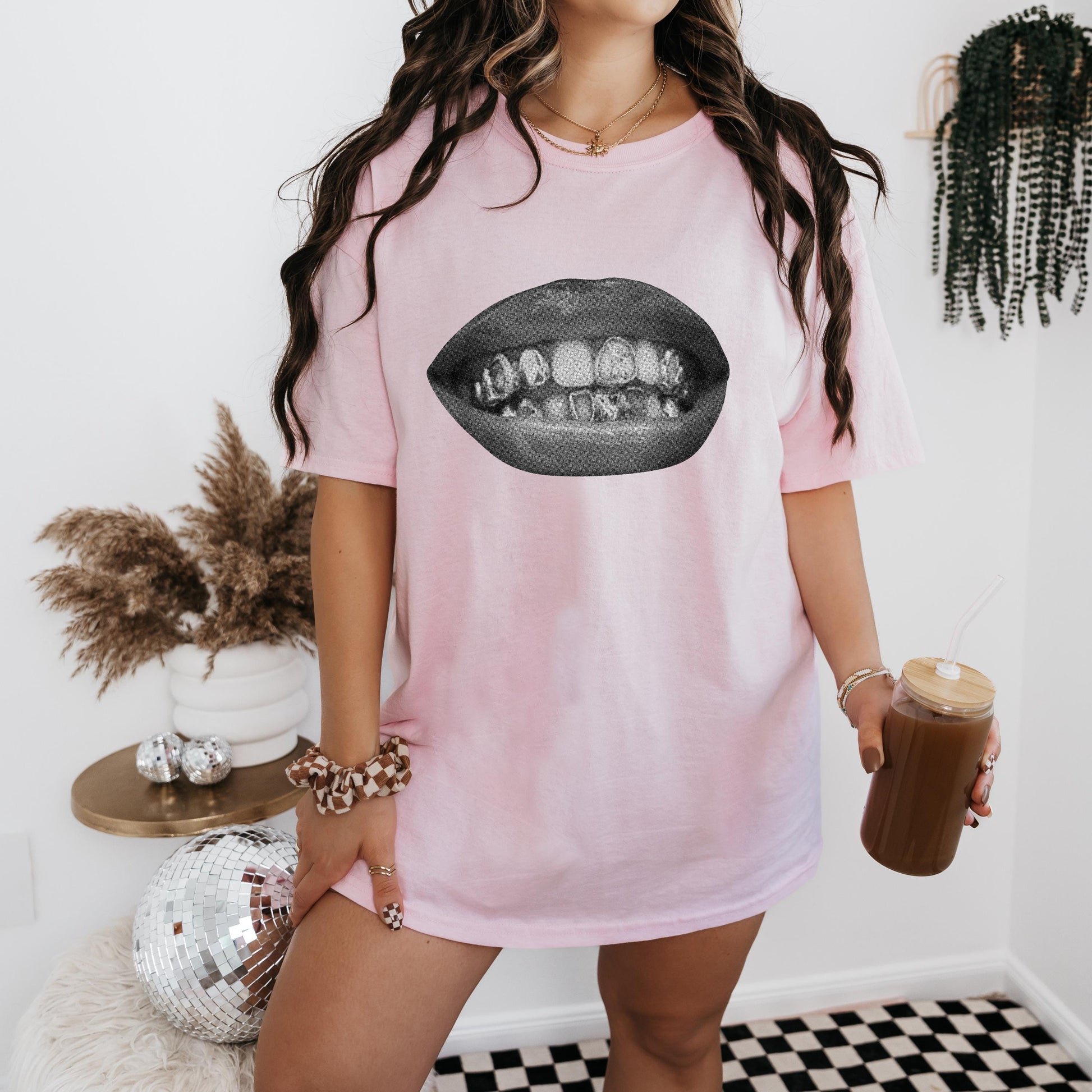 a woman in a pink shirt holding a cup of coffee