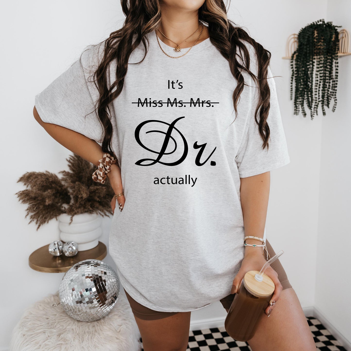 a woman standing in a room holding a cup of coffee