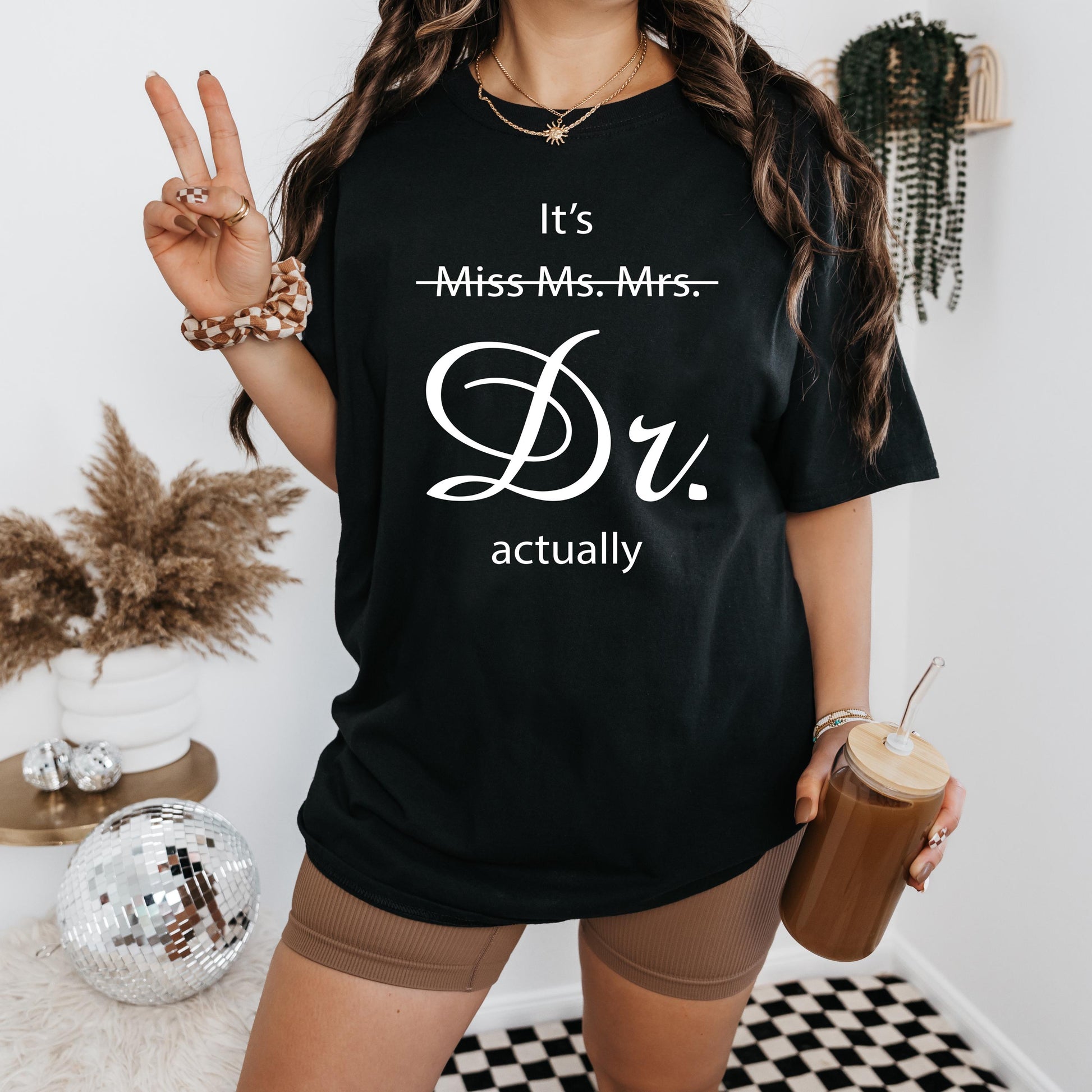 a woman in a black t - shirt is holding a drink