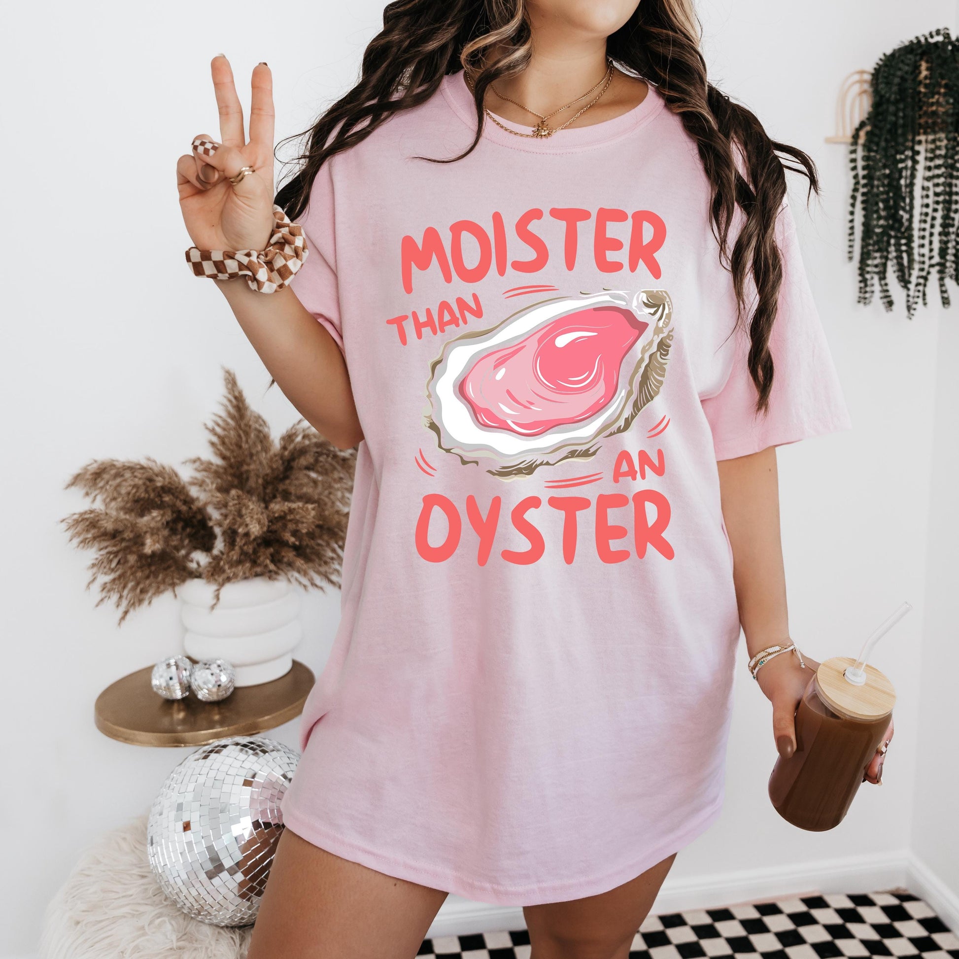 a woman in a pink shirt holding a cup of coffee