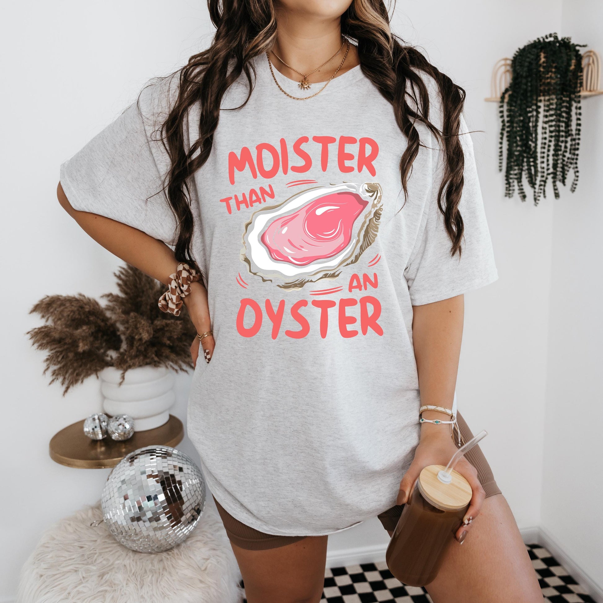 a woman standing in front of a wall holding a cup of coffee